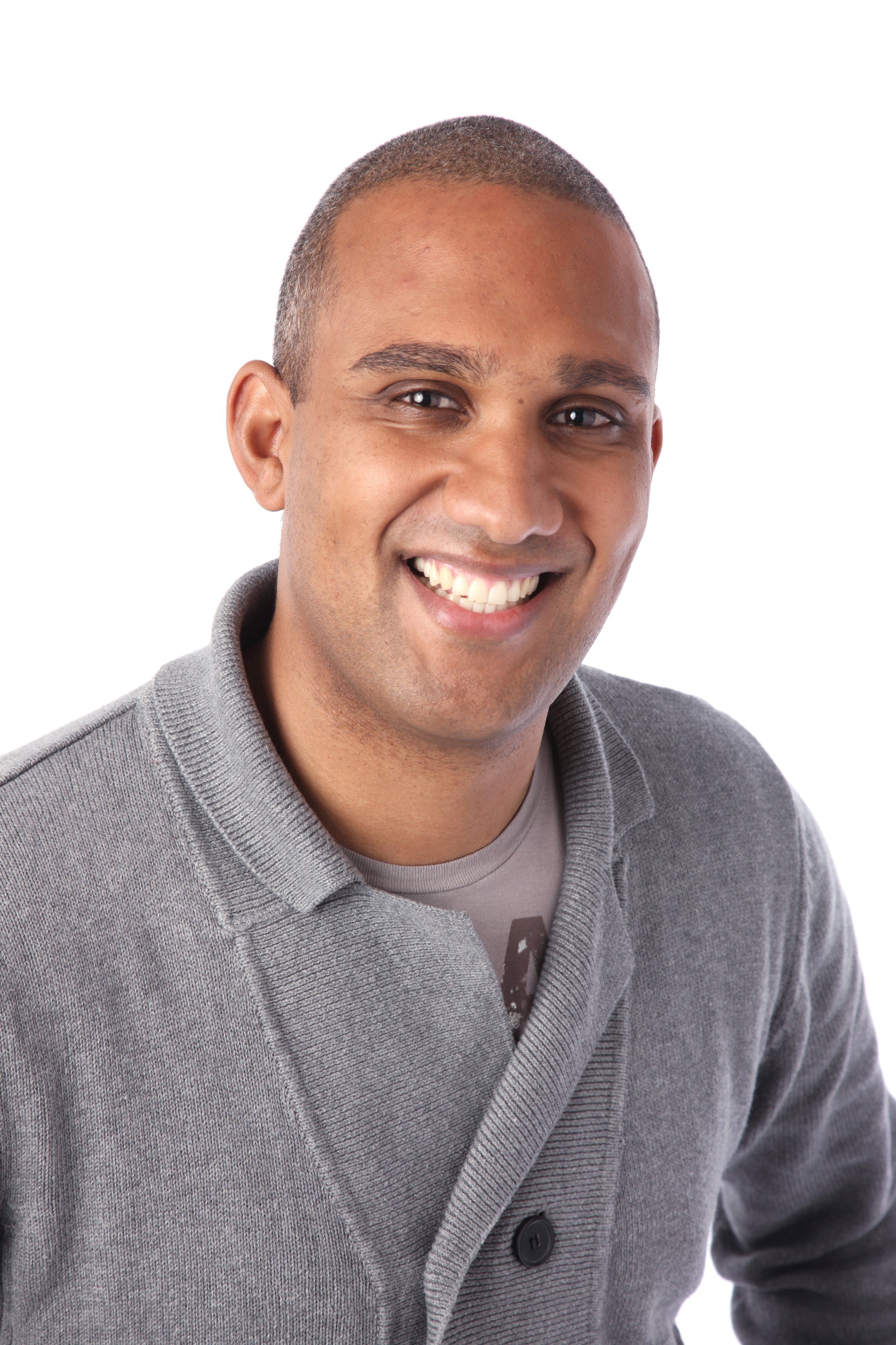 The picture shows a smiling life coach named Marcus Abrahams. He looks relaxed in a soft grey cardigan and tee shirt.